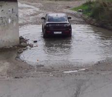 حفرة مليئة بالمياه تعيق حركة السيارات وتشكل معاناة للمواطنين قرب جسر العقيبة في ريف جبلة (فيديو)